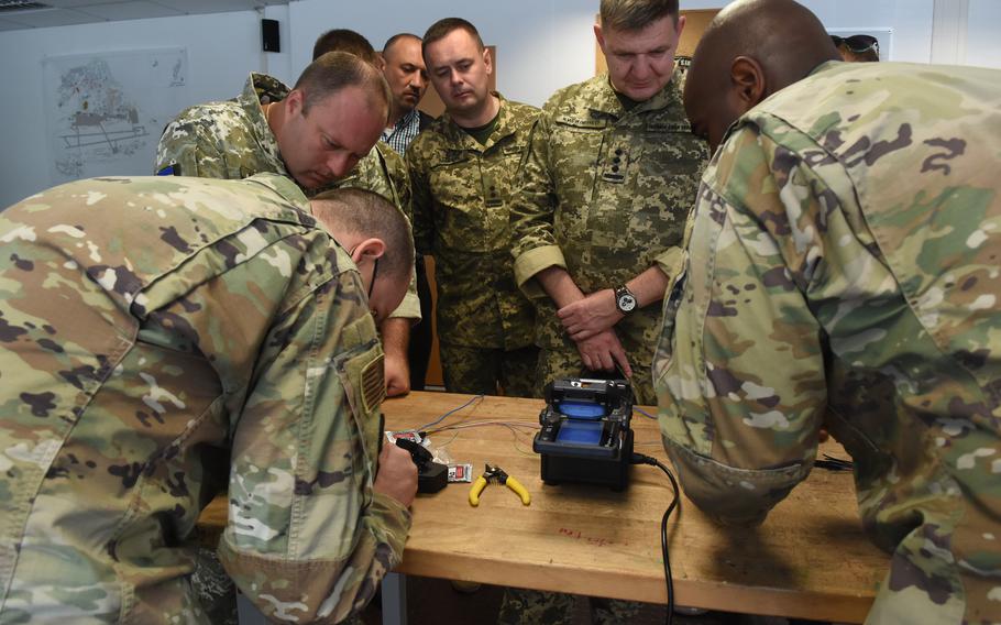 Airmen with the 1st Communications Maintenance Squadron show members of the Ukraine air force a machine that can repair fiber optic cables at Kapaun Air Station in Kaiserslautern, Germany, Aug. 5, 2021.