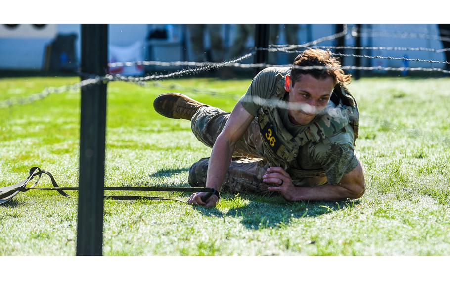 Army Capt. Luke Ebeling crawls under razor wire during the second day of the Best Ranger Competition, Saturday, April 15, 2023, at A.J. McClung Memorial Stadium in Columbus, Ga. Ebeling and his teammate Spc. Justin Rein, both from the 75th Ranger Regiment, went on to win the 39th annual competition. 