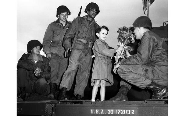 Nancy, France, September, 1954: Seven-year-old Jacques Loisy presents a bouquet to Sgt. Kenneth Gammons during ceremonies commemorating the tenth anniversary of the liberation of the city by Allied troops during World War II. Looking on are, left to right, Sgt. Samuel Henricks, Pvt. Joseph Hafele and Pfc. Alfred Allen.

Looking for Stars and Stripes’ historic coverage? Subscribe to Stars and Stripes’ historic newspaper archive! We have digitized our 1948-1999 European and Pacific editions, as well as several of our WWII editions and made them available online through https://starsandstripes.newspaperarchive.com/

META TAGS: WWII; World War II; anniversary; DDAY80; 