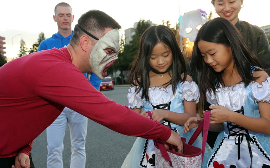 A soldier gives out Halloween candy during a trunk-or-treat event at Sagamihara General Depot, Japan,  Oct. 24, 2018. 
