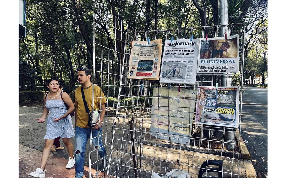 Bystanders walk by a newspaper rack in Mexico City’s Parque Mexico. Many of the headlines are dominated by talk of threats of U.S. military intervention to take on cartels and fentanyl labs. 
