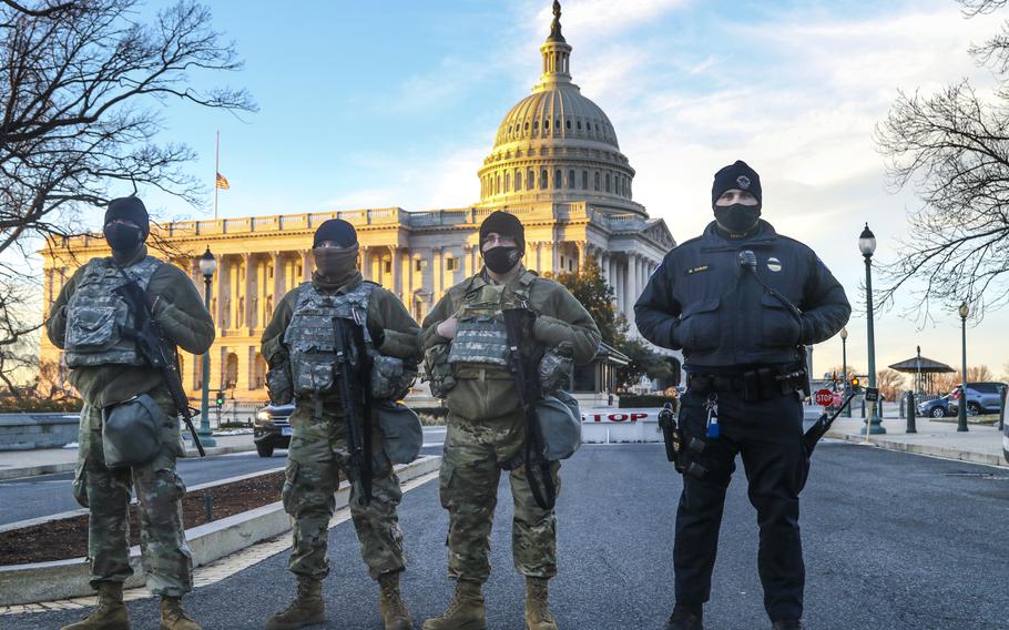 From left, Army Sgt. Gio Carter, Sgt. Aaron Hampton, and Pvt. Cody Harrison, all with Forward Support Company, 507th Engineer Battalion of the Michigan National Guard, provide security with U.S. Capitol Police officer Mitchell Dunay near Capitol Hill in Washington, D.C., on Feb. 3, 2021. 