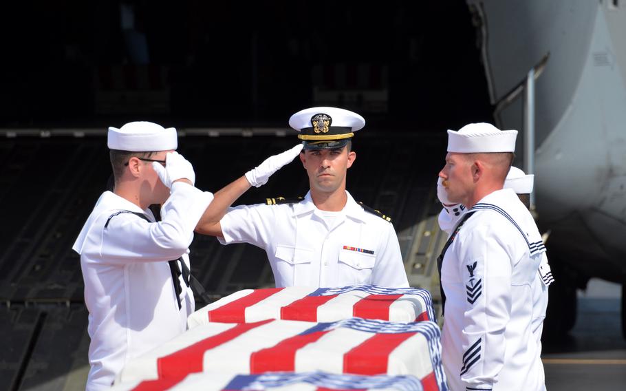 Sailors salute during an honorable carry ceremony for the remains of USS Oklahoma service members at Joint Base Pearl Harbor-Hickam, Hawaii, Thursday, June 24, 2021.