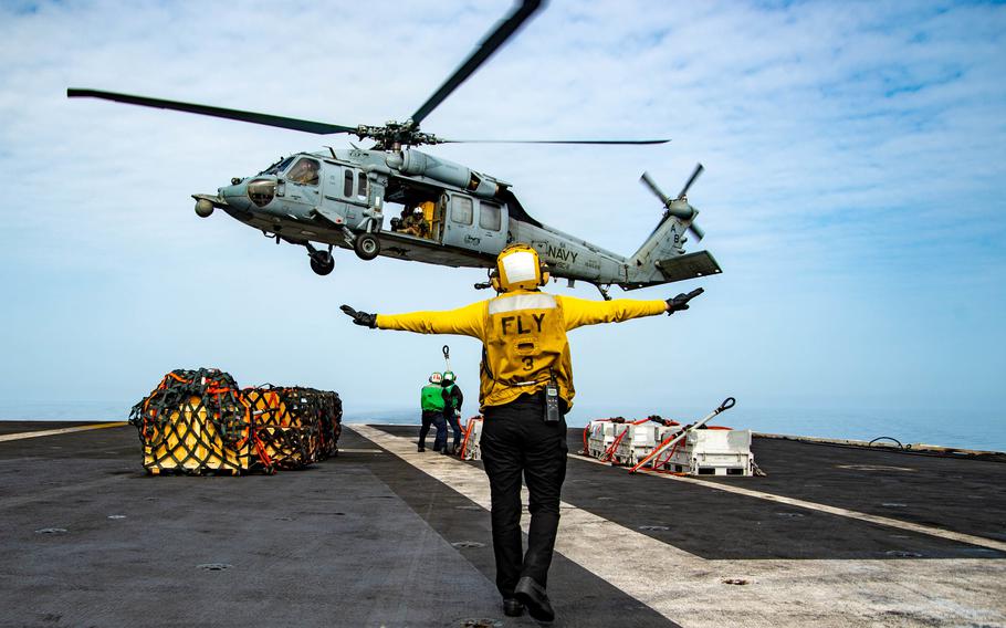Petty Officer 3rd Class Kallista Zimmerman directs the pilot of an MH-60S Sea Hawk helicopter on the flight deck of the  aircraft carrier USS Harry S. Truman in the Adriatic Sea, March 29, 2022. The Truman carrier strike group's deployment to the 6th Fleet area of operations has been extended.