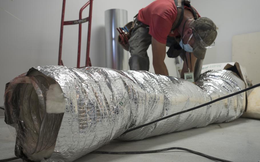A worker installs a negative air pressure HVAC system during construction for pharmacy area expansion at Katherine Shaw Bethea Hospital in Dixon, Ill., on August 24, 2021.