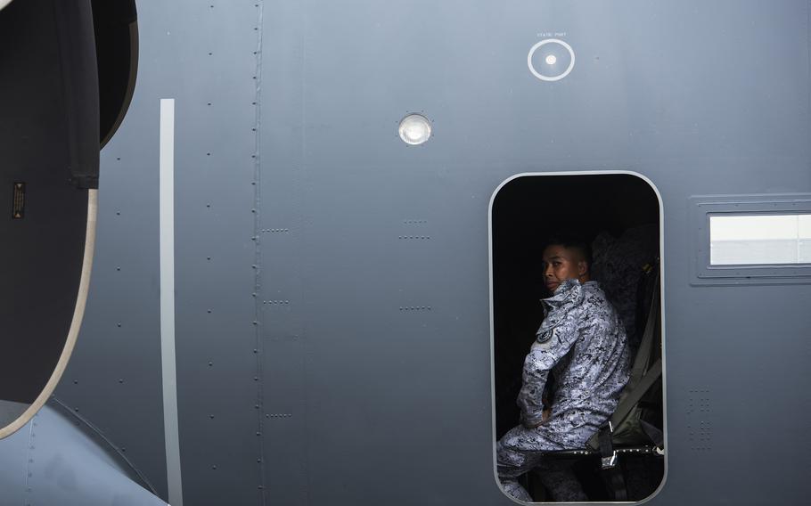 A Philippine navy sailor looks out the paratroop door of an Air Force AC-130J Ghostrider gunship at the former home of Naval Air Station Cubi Point, Philippines, April 23, 2023.