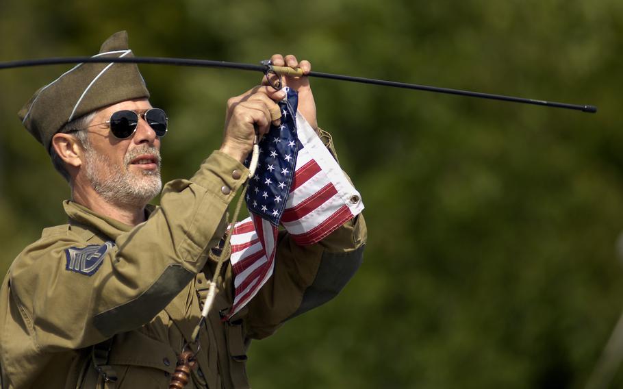 A re-enactor attaches a U.S. flag to the antenna of his jeep June 5, 2009 at the  Normandy American Cemetery in France. 
