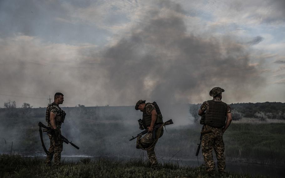 Ukrainian soldiers in the eastern Ukrainian village of Vstupky after Russian artillery struck a nearby field, setting it on fire, on June 1, 2022. Moscow has redirected nearly all its remaining artillery on the battlefield to a single area in hopes of accomplishing its new stated goal of taking all of Ukraine’s eastern Luhansk and Donetsk regions, which together comprise Donbas. 