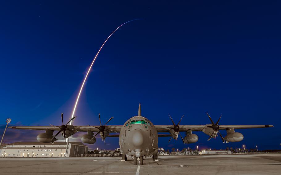 A 920th Rescue Wing HC-130J Combat King II aircraft sits on the flight line at Patrick Space Force Base, Fla., as the Inspiration4 rocket launches in the background. Inspiration4 is the world’s first all-civilian mission to orbit.
