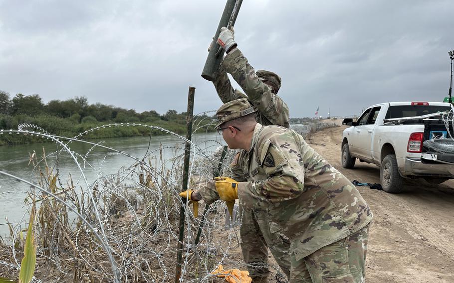 Texas National Guard soldiers build a coiled wire barrier near the U.S. border with Mexico as part of Operation Lone Star, a state-sponsored mission to deter migrants from crossing into the U.S. between legal ports of entry. 