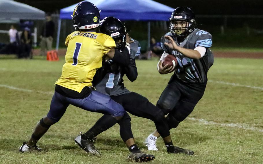Guam High's Noah Harris tries to fight his way through a Southern block to get to Dolphins ballcarrier Donte Salas.