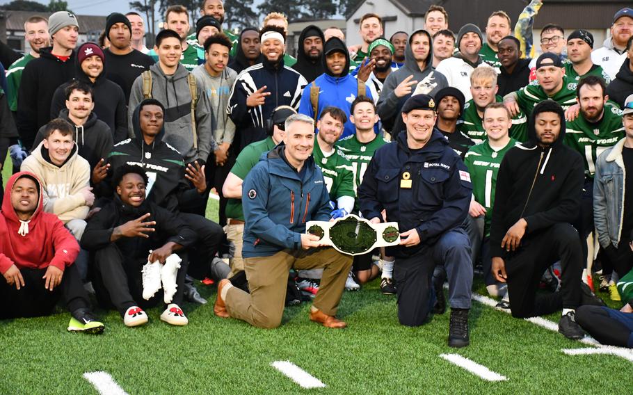 Brig. Gen. Joseph Campo, left, commander of the 48th Fighter Wing at RAF Lakenheath, and Royal Navy Commodore Steve Prest hold the winners’ belt, which was donated by the New York Jets, after a friendly matchup sponsored by the NFL team on Friday.