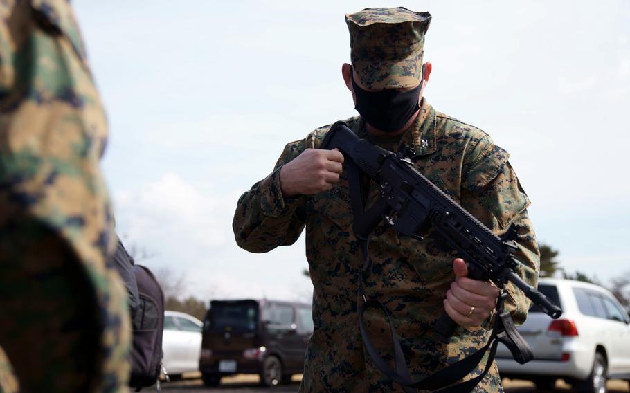 The commander of the 31st Marine Expeditionary Unit, Col. Michael Nakonieczny, inspects a firearm during a joint exercise with the Japan Ground Self-Defense Force near Mount Fuji, March 15, 2022. 