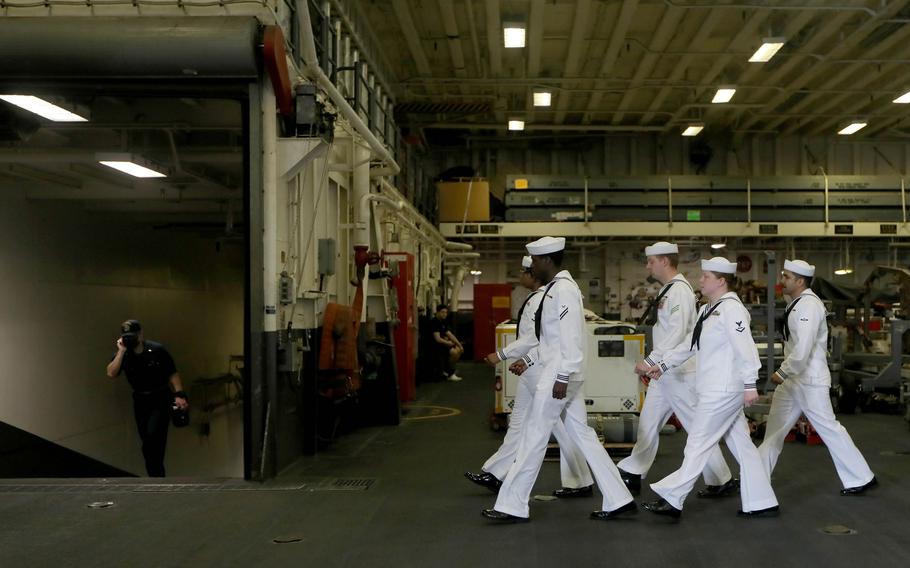 Sailors work aboard the amphibious assault ship USS America while docked at Manila's South Harbor, Tuesday, March 21, 2023.