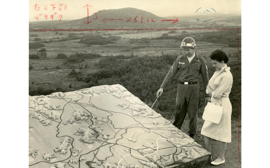 Pfc. Joseph Anderson shows Holiday on Ice star Elyane Lattes a briefing map in relief at Outpost Maizie on the Demilitarized Zone (DMZ) in Korea. Lattes was the latest celebrity to visit the outpost to peer at some communists across the DMZ. OP Maizie was popular with the VIP crowd — at least one VIP visited per week.