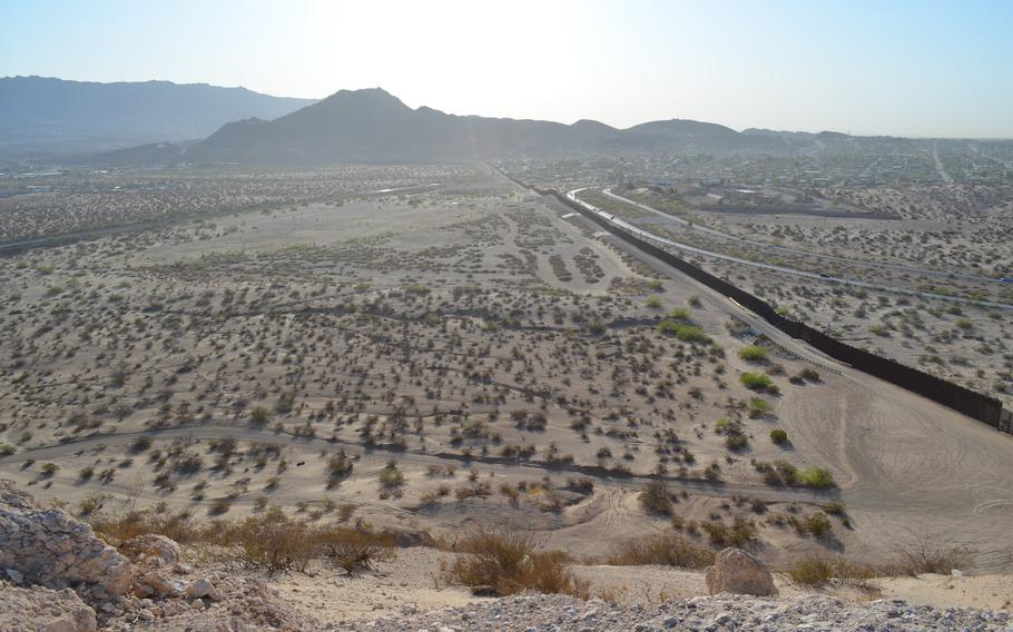 Photo of the desert along the U.S.-Mexico border. The border wall is seen.
