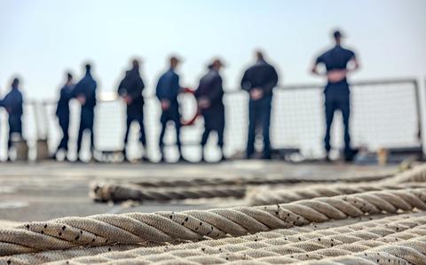 Sailors stand near the rails of a ship in South Korea.