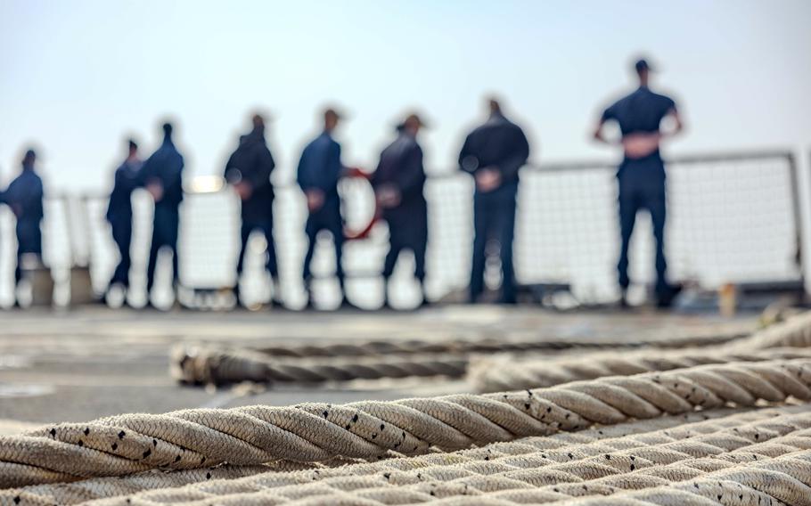 Sailors stand near the rails of a ship in South Korea.