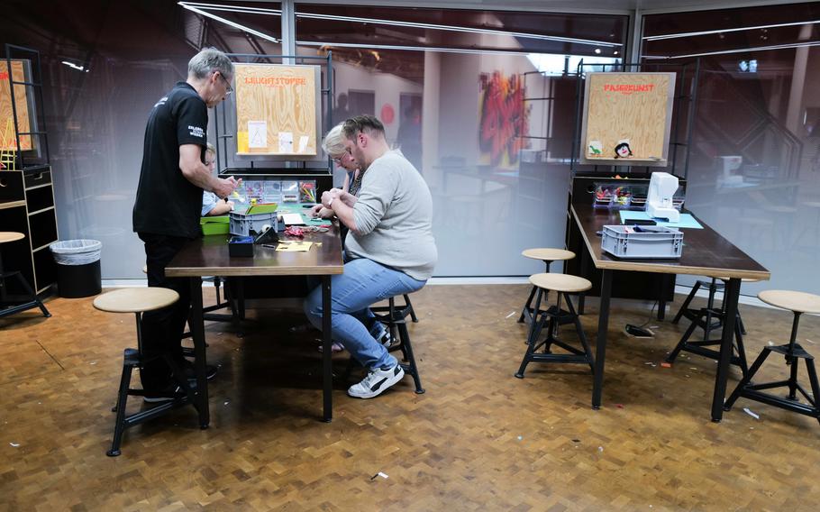 A family works together on lighting fixtures in the Maker Lab at the Experimenta Science Center. The lab features instructors that walk visitors through guided creative experiments with a variety of materials.