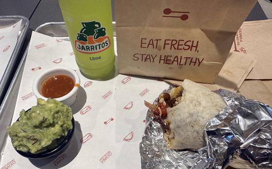 A steak burrito, a bottle of Jarritos, chili sauce and a generous serving of gucamole from Cuchara in Suwon, South Korea.