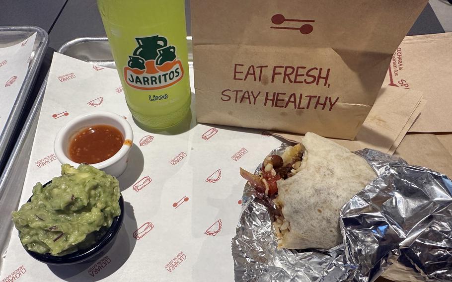A steak burrito, a bottle of Jarritos, chili sauce and a generous serving of gucamole from Cuchara in Suwon, South Korea.