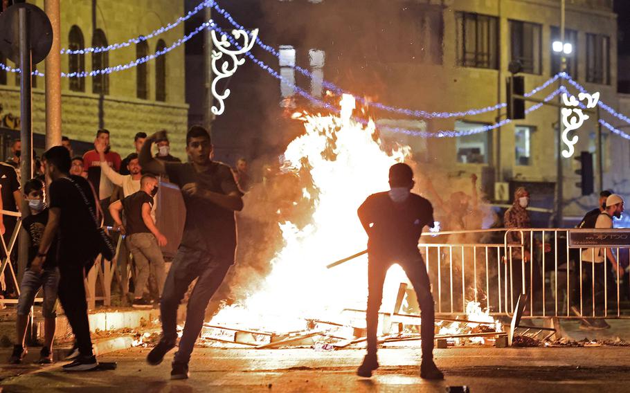 Palestinian protesters hurl stones at Israeli security forces amid clashes in Jerusalem's Old City on Saturday, May 8, 2021.