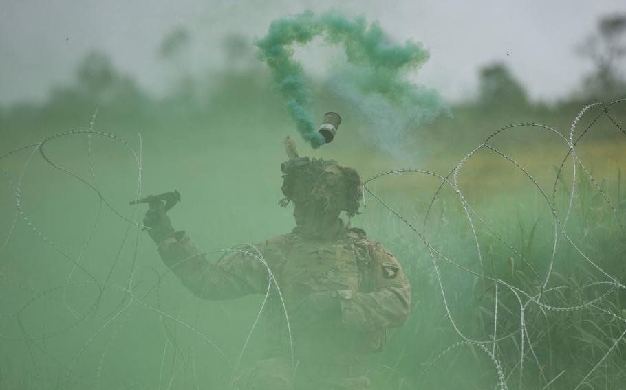 A soldier with the 101st Airborne Division cuts through concertina wire