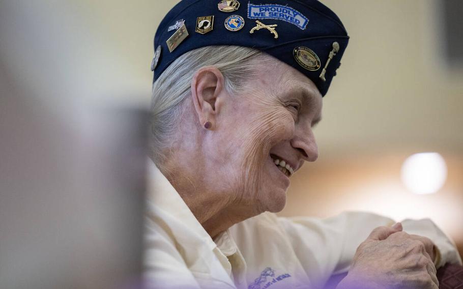 A retired Army sergeant smiles as she listens to a speaker.