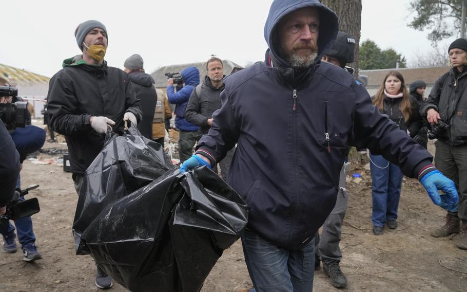 Police carry a dead body of one of six civilians - three women, one teenager girl and two men who were found in Bucha, close to Kyiv, Ukraine, Tuesday, Apr. 5, 2022. 