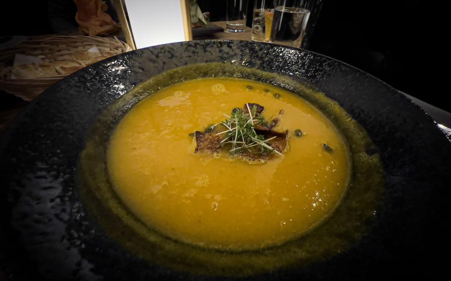 A bowl of pumpkin mango curry soup served as an appetizer at Alte Post in Neckarsulm, Germany, Dec. 20, 2023. The dish combines the sweetness of mango with the earthiness of pumpkin and is topped with roasted pumpkin seeds for added texture.