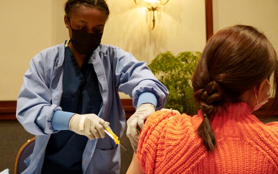 
Niyona Gibbs, a nurse with Navy Medicine Readiness and Training Command at Yokosuka Naval Base, Japan, gives a COVID-19 vaccine shot at the New Sanno Hotel in Tokyo, Feb. 16, 2022. 