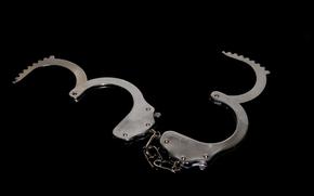 Handcuffs laid against a black background.