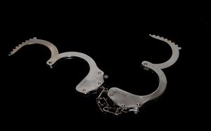 Handcuffs laid against a black background.