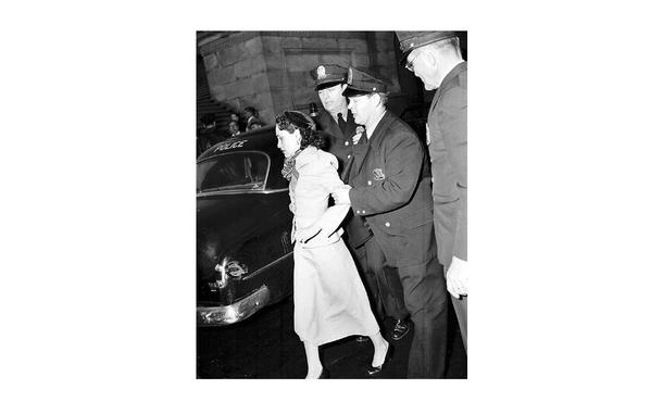 Police lead away Puerto Rican nationalist leader Lolita Lebron on March 1, 1954, following her arrest in the shooting of five congressmen in the House of Representatives. 