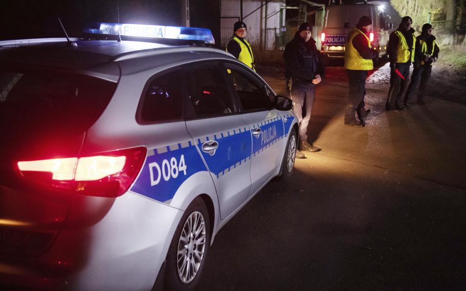 Police officers gather Tuesday, Nov. 15, 2022, outside a grain depot in Przewodow, eastern Poland, where the Polish Foreign Ministry said that a Russian-made missile fell and killed two people.