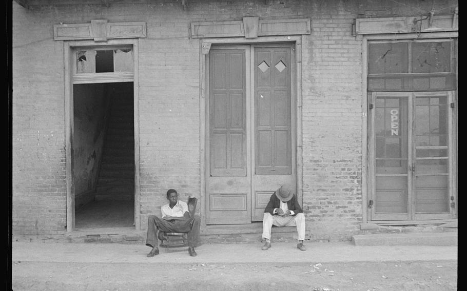 Black residents of Natchez, Miss., sit outside a building in 1935. 