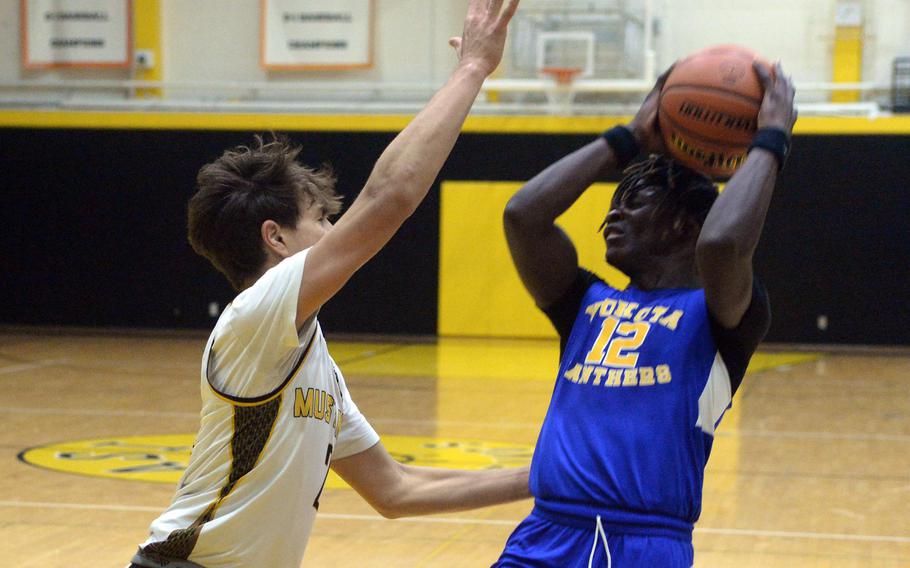 American School In Japan's Shou Murakami-Moses defends against Yokota's Jai Bailey. The Mustangs won 51-32.