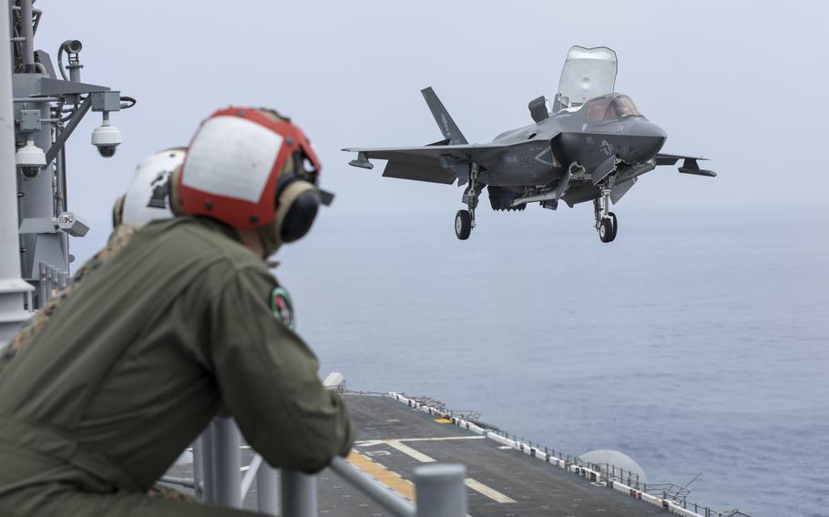 
Members of Marine Fighter Attack Squadron 121 watch an F-35B Lightning II stealth fighter land aboard the amphibious assault ship USS Tripoli while underway in the Western Pacific, May 24, 2022.