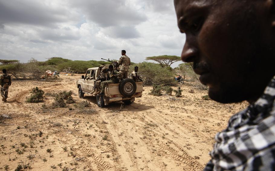 Soldiers in the back of a pickup truck.