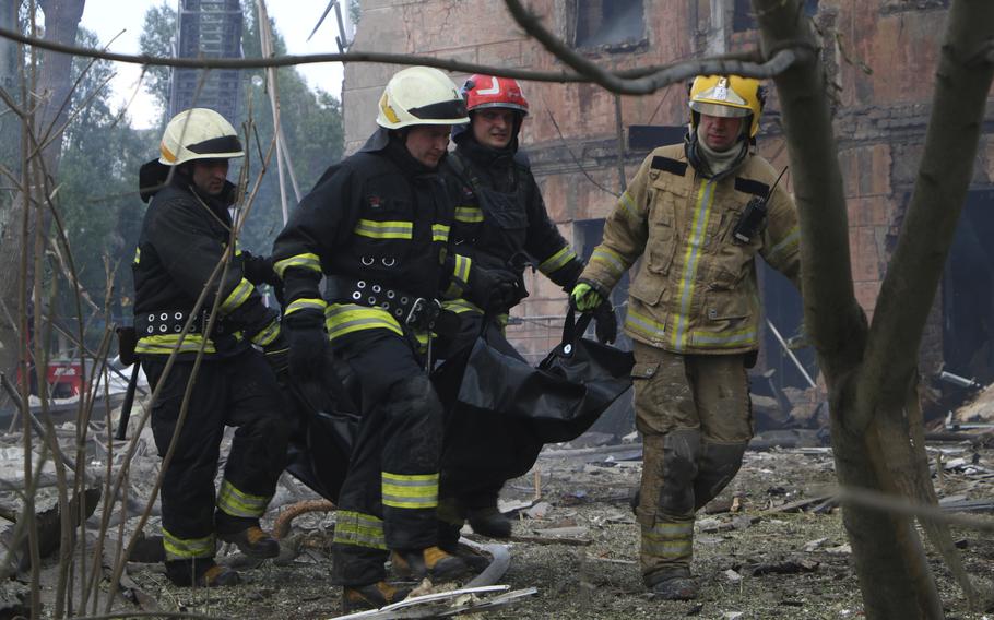 In this handout photo by State Emergency Service of Ukraine, firefighters carry a body which was killed at Policlinic after a Russian attack in Dnipro, Ukraine, on Friday 26 May 2023. At list one person was killed and 15 were injured. 