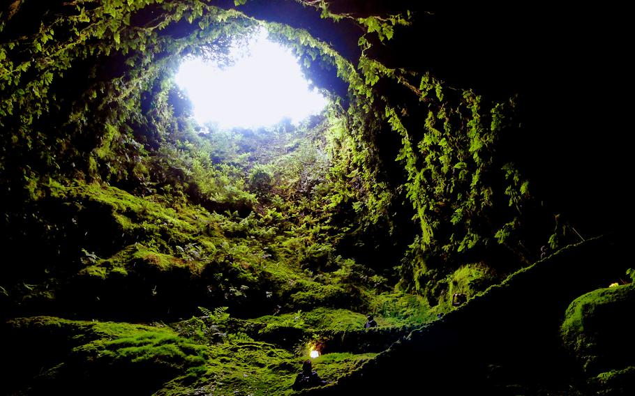 Visitors hike down the lava tube in the Algar do Carvão volcanic cave on Terceira in the Azores. 