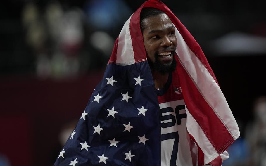 Kevin Durant celebrates with an American flag after Team USA won the men’s gold medal basketball match against France on Aug. 6, 2021. Durant entered the NBA’s health and safety coronavirus protocols on Saturday, Dec. 18.