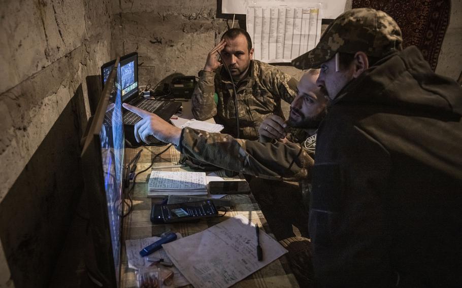 Soldiers from Ukraine’s 77th Brigade watch for Russian soldier movement on live video feeds from drones hovering above Bakhmut in an underground base in Chasiv Yar on April 21, 2023. 