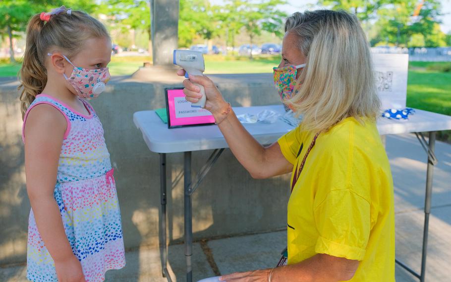 A girl has her temperature taken on her first day of school in Mount Pleasant, Michigan, on Aug. 24, 2020. The Centers for Disease Control and Prevention issued a nationwide health alert Thursday about an unusual cluster of serious hepatitis cases in young children for which the cause or causes is not known.