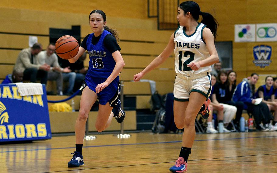 Rota sophomore Jourdan Timmons dribbles up the court while Naples guard Anais Navidad gives chase during a Division II semifinal at the DODEA European Basketball Championships on Feb. 16, 2024, at Wiesbaden High School in Wiesbaden, Germany.