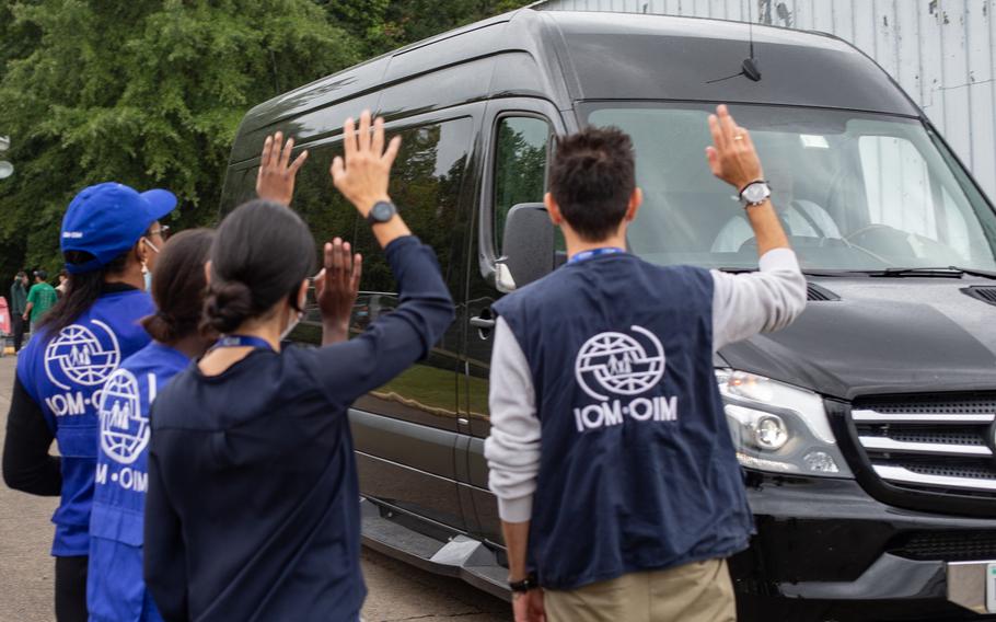 Members of the International Organization for Migration wave to an Afghan family as they depart temporary housing at Marine Corps Base Quantico, Va., on Sept. 22, 2021. Resettlement agencies provide vital assistance to refugees transitioning to their new homes.