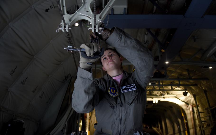 Senior Airman Marissa Antillonloya, a loadmaster with the 37th Airlift Squadron, adjusts a cable inside a C-130J for a static line jump. Antillonloya was one of 17 women who flew on an all-women, three-aircraft formation training flight on March 18, 2022, out of Ramstein Air Base.
