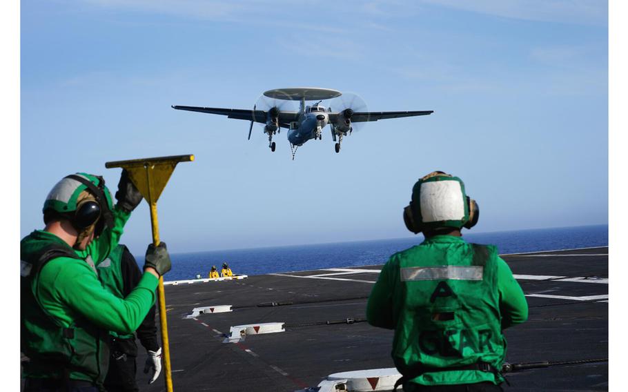 Flight deck crew members stand by during recovery as several E-2 Hawkeye aircraft return to land on the deck of the USS Carl Vinson (CVN 70) on July 12, 2023.