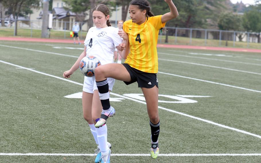 Robert D. Edgren's A'mya Ross and Zama's Juliet Bitor try to play the ball during Saturday's game. Ross scored all three goals for the Eagles in their 3-2 win over the Trojans.