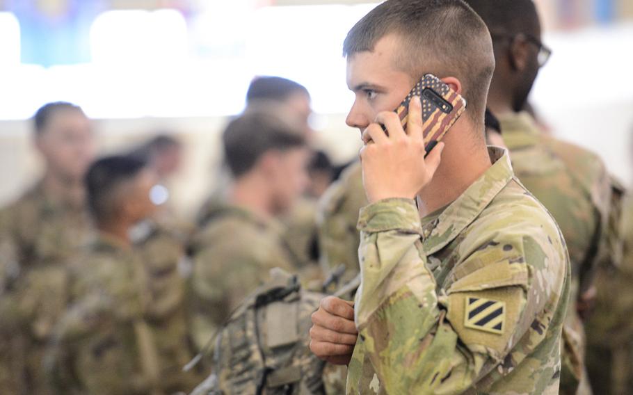 An Army sergeant with 3rd Battalion, 69th Armored Regiment talks on the phone just before boarding a flight to Germany as part of a short-notice deployment to Europe at Hunter Army Airfield, Ga., on Wednesday, March 2, 2022. The 1st Armored Brigade Combat Team, 3rd Infantry Division — including 3-69 Armor — was ordered to Europe on a short-notice deployment after Russia invaded Ukraine. 
